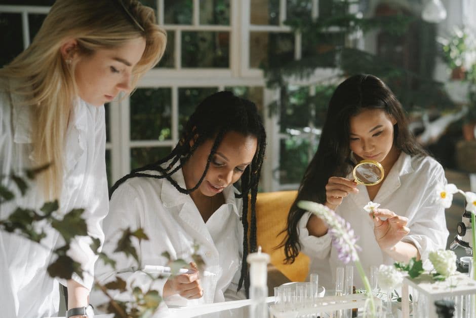 Women scientists engaging in botanical research, examining plant samples indoors.