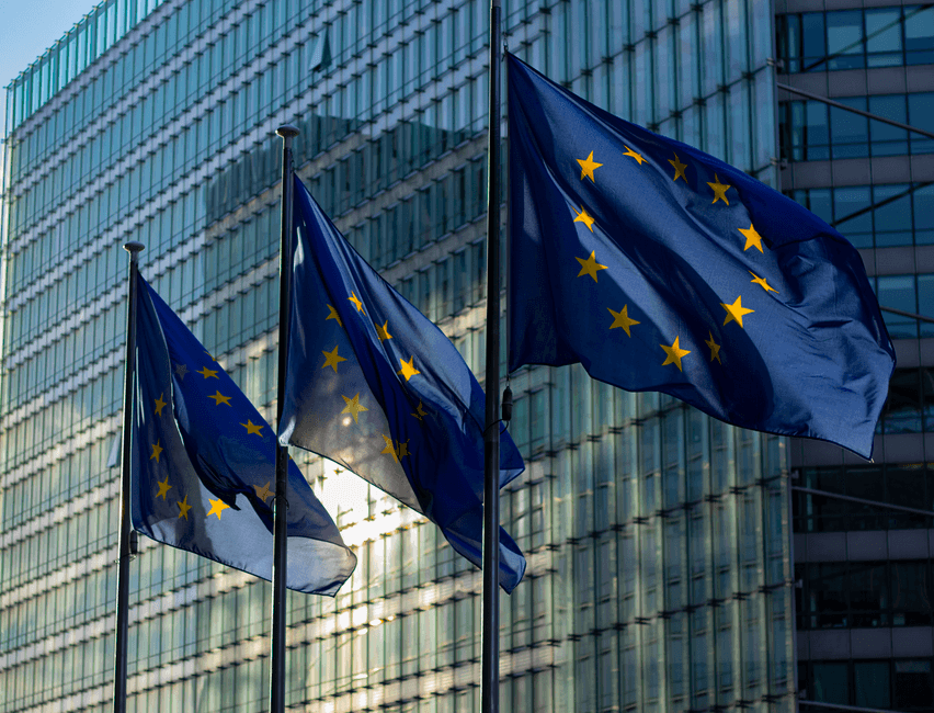 EU flags waving in front of the European Commission building in Brussels, Belgium.