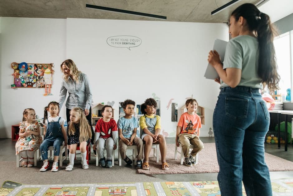 Diverse group of preschool children and teachers in an engaging classroom setting.