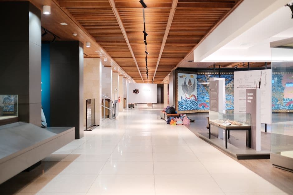 Bright museum hallway with exhibits and empty walkways, showcasing modern design.