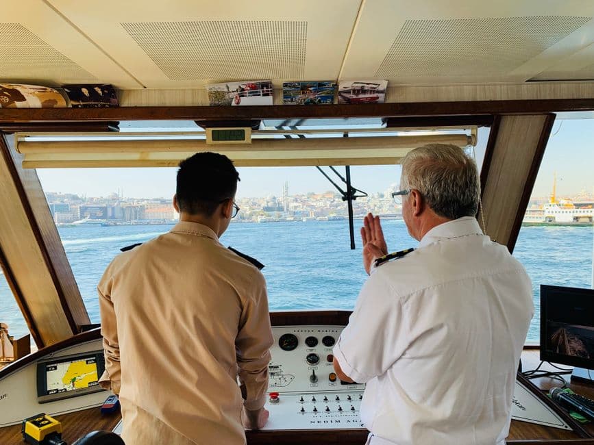 Ship captain and crew member discussing navigation on the Bosphorus in Istanbul.