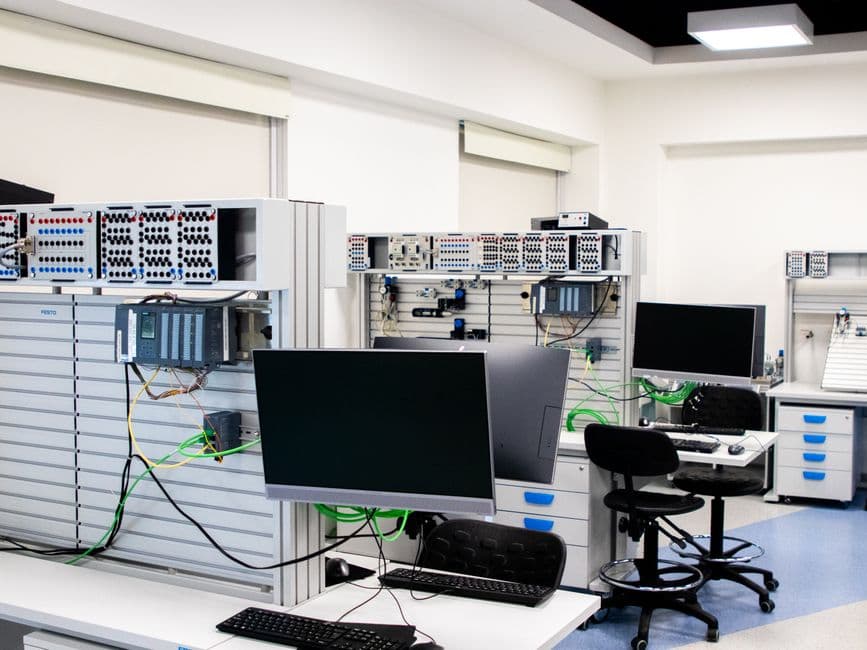 A contemporary computer lab with advanced workstations and electronic equipment, perfect for research and development.