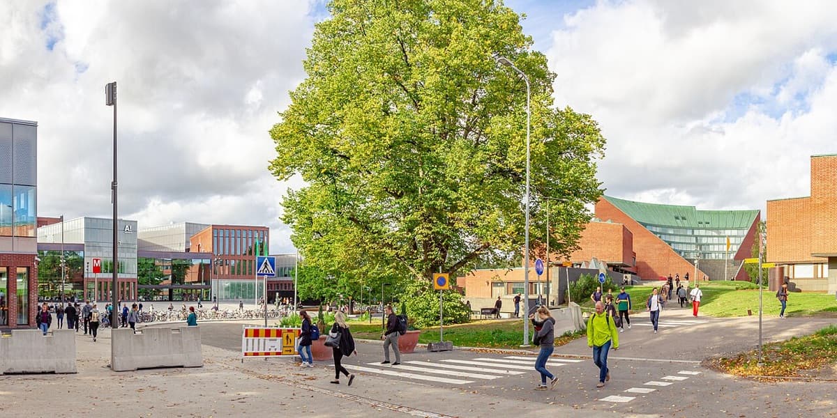 Aalto University modern campus plaza with multiple contemporary buildings and people.