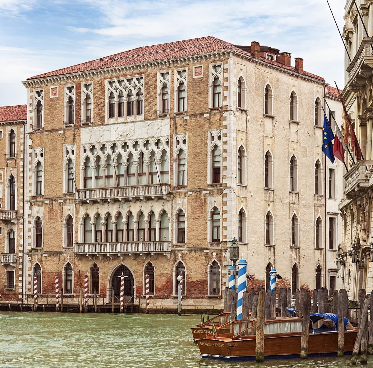 The elegant palazzo facade of Ca' Foscari University with Gothic and Renaissance architectural details on the Grand Canal in Venice.