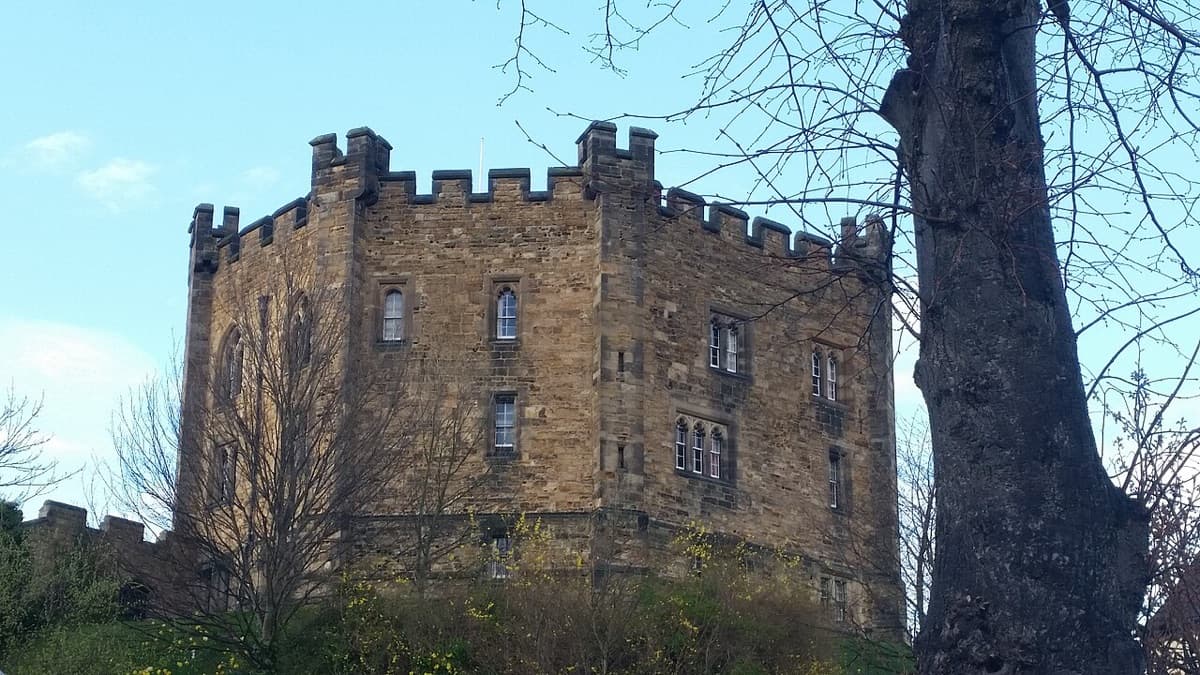 The Norman keep of Durham Castle, home to University College, Durham University, under a clear sky.