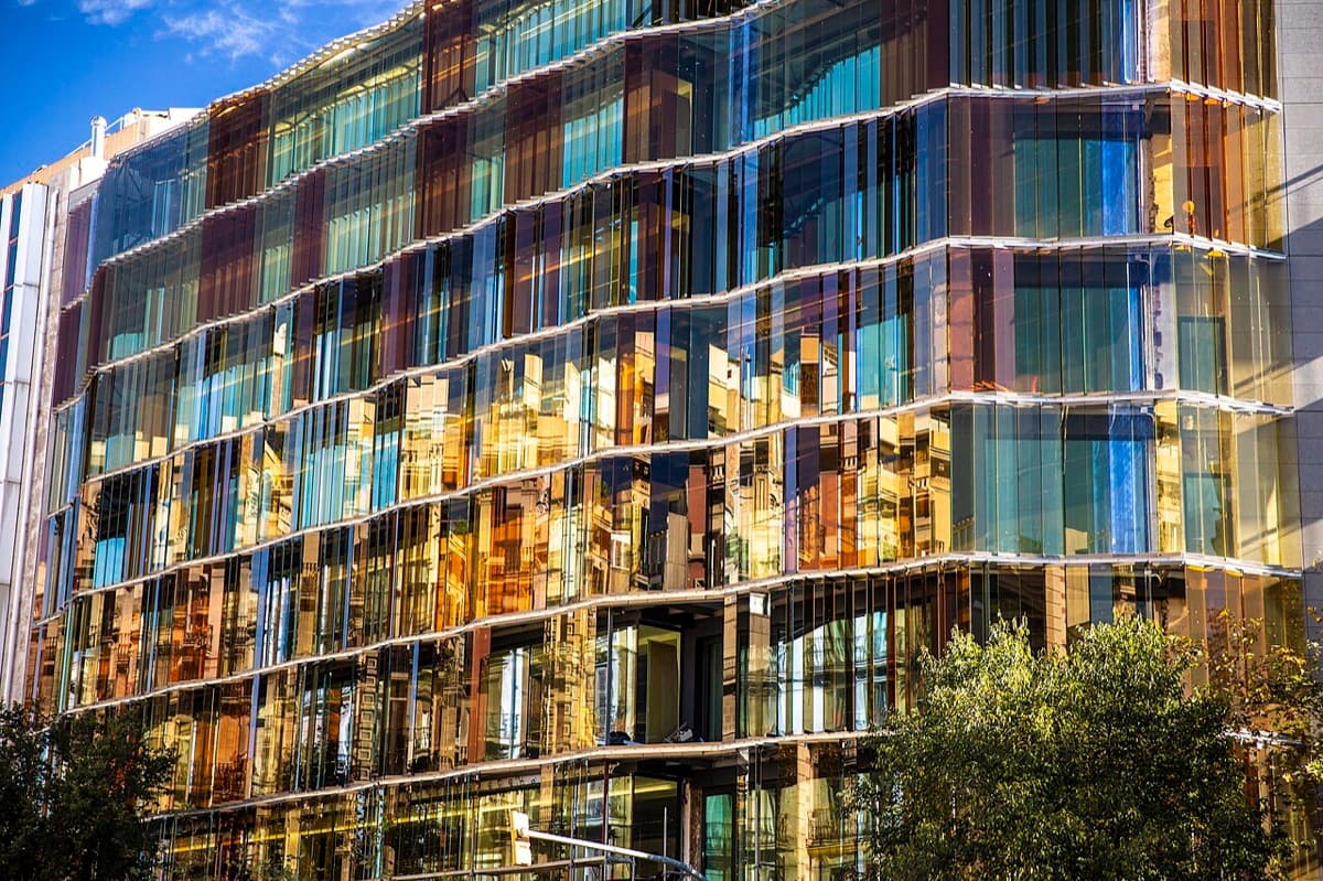 Modern glass-fronted building of EADA Business School with curved transparent facade in Barcelona.