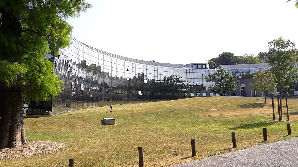 EDHEC Business School Lille campus featuring distinctive curved modern architecture in white and glass with campus greenery.