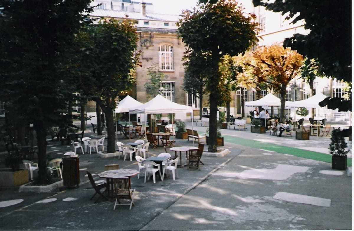 Historic interior courtyard of ESCP Paris campus showing classical French architecture with tree-lined plaza and ornate stonework.