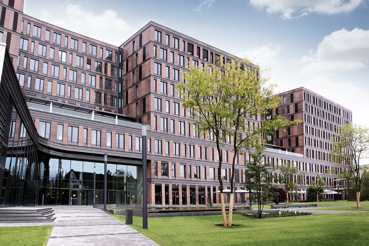 Frankfurt School of Finance modern red-brick campus complex with plaza, courtyard, and landscape.