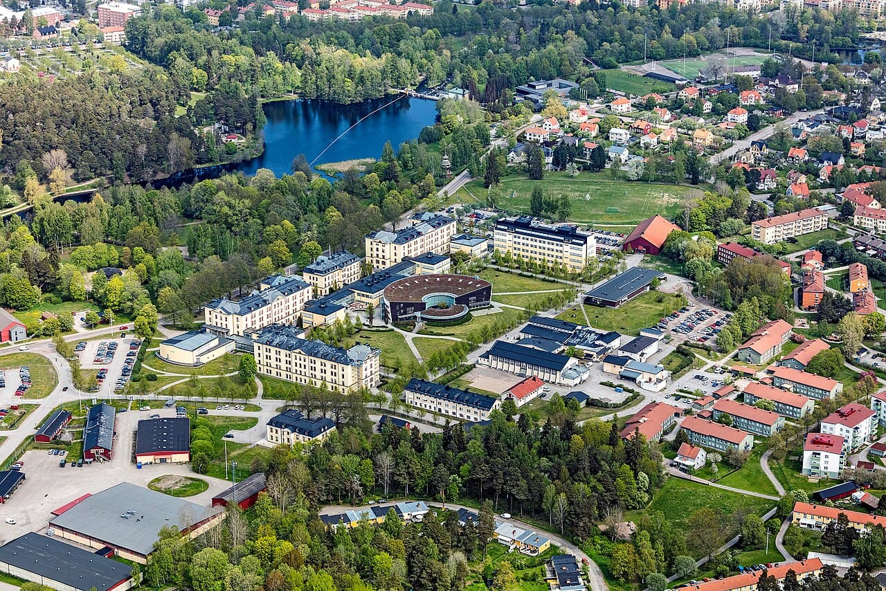 Flygfoto över Högskolan i Gävle med omgivningar. I bilden syns delar av campusområdet, Strömvallen och Gavleån.