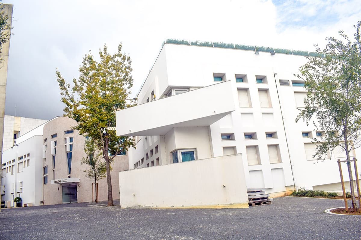 The white modernist campus building of ISCTE University Institute of Lisbon, with its cantilevered upper floor over the forecourt.