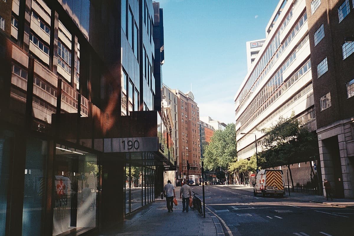 London School of Economics campus street showing red brick university buildings along Houghton Street with institutional facades.