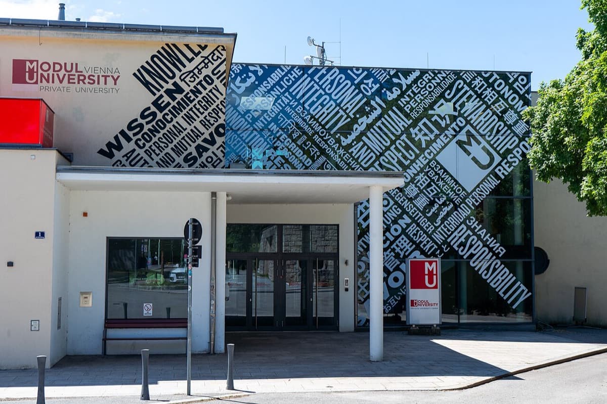 Front entrance building of MODUL University Vienna showing contemporary institutional architecture with signage in bright daylight.