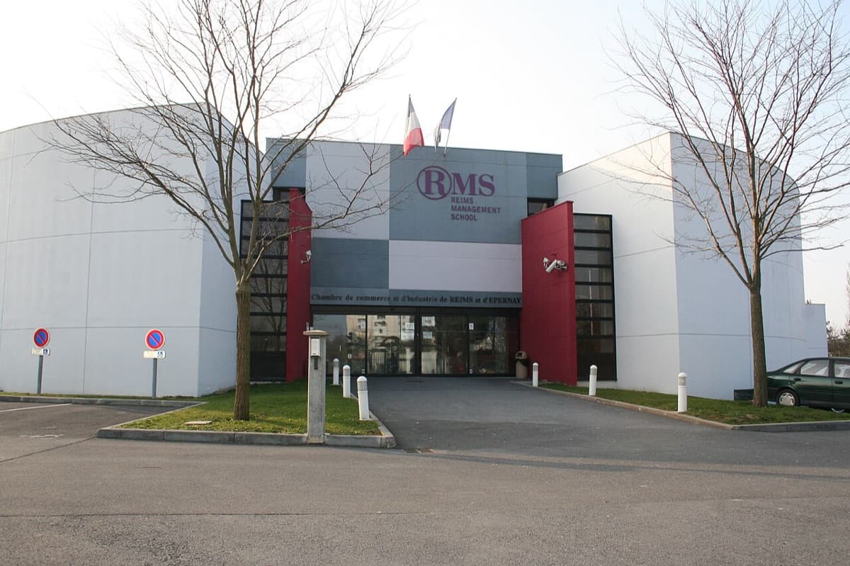 NEOMA Business School campus building showing distinctive modern architecture with white and red design elements and clear school signage.