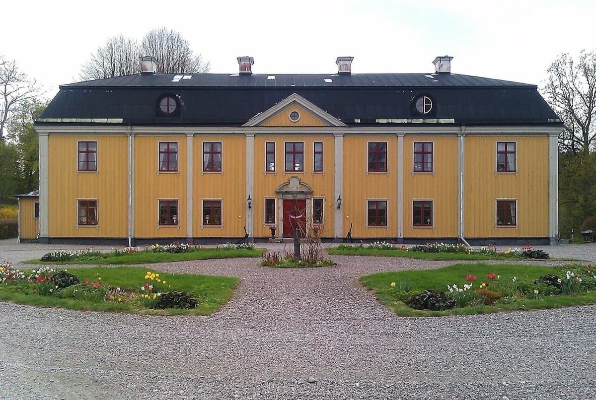 Tvetabergs säteri, the historic estate building where Saint Ignatios Theological Academy is housed, showing cream and yellow facade with characteristic Swedish manor architecture.