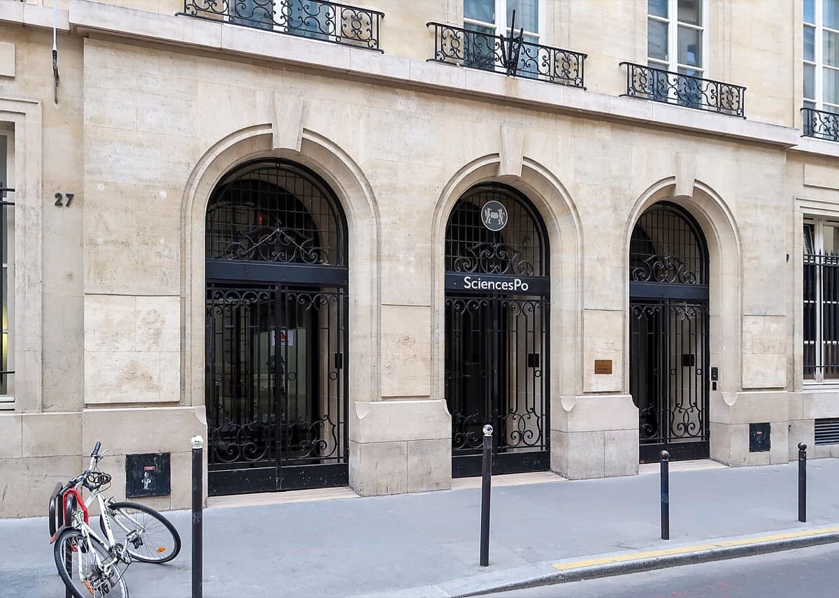 Sciences Po Paris historic building facade on rue Saint-Guillaume showing classic Haussmann architecture with ornate arched entrances and 'SciencesPo' signage.