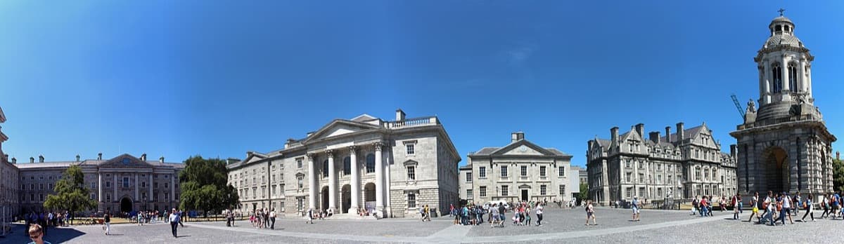 Dublin Trinity College Parliament Square showing iconic neoclassical buildings and bell tower with people in daylight.
