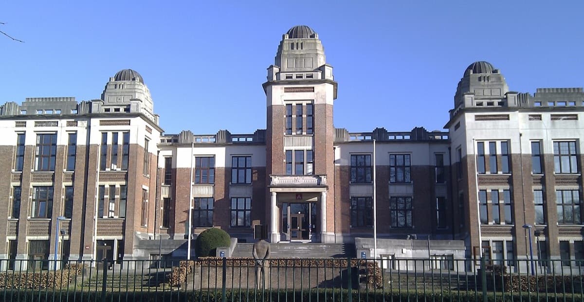 Historic brick and stone building of University of Antwerp with ornate facade, distinctive domed towers, and classical institutional design.