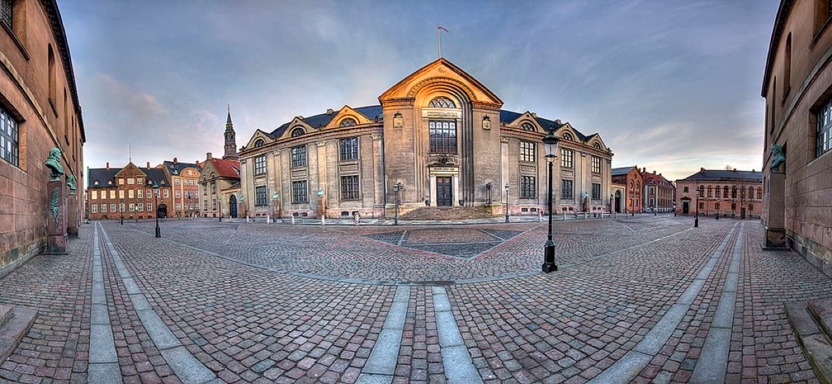 Neoclassical main building of University of Copenhagen in courtyard setting.