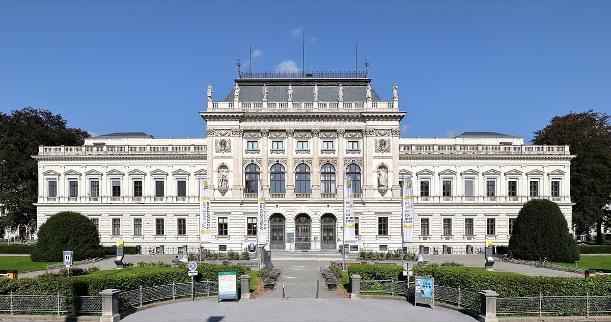Main neoclassical white building of University of Graz with symmetrical facade and grand architectural proportions in daylight.