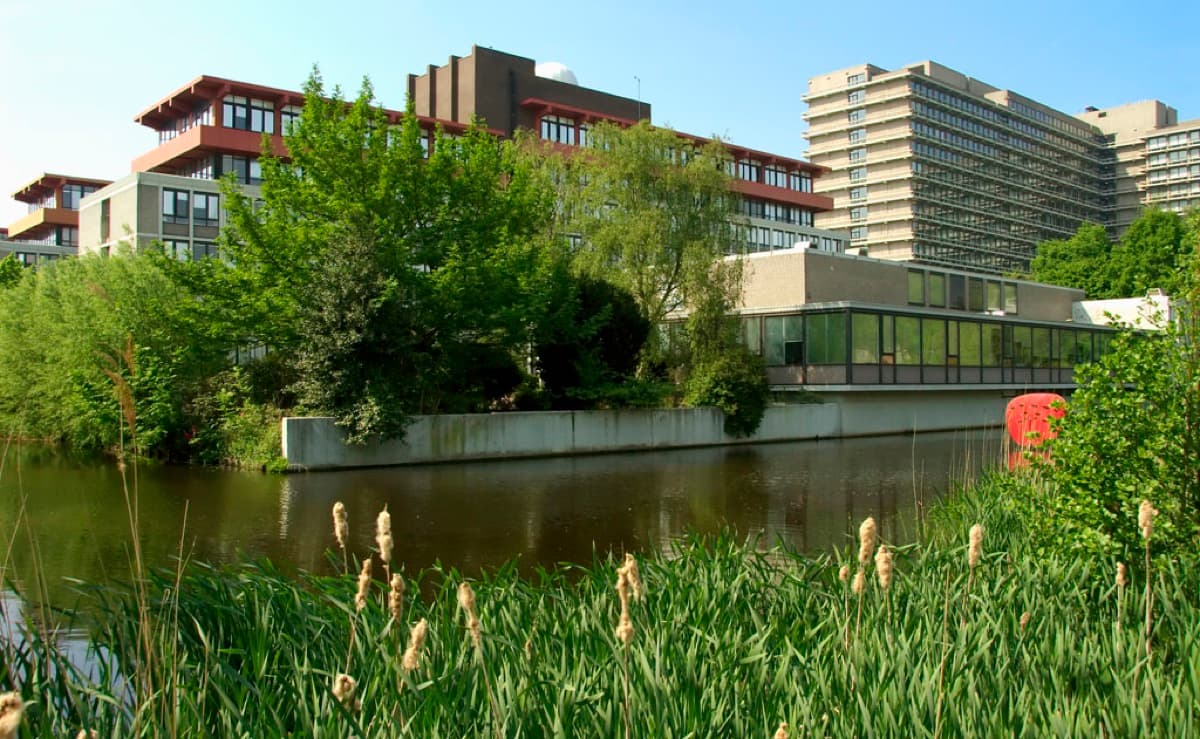 VU campus buildings viewed across water with modern institutional architecture and green landscaping.